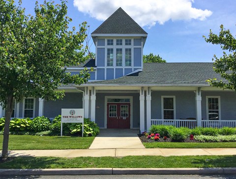 a building with a red door and a sign in front of it