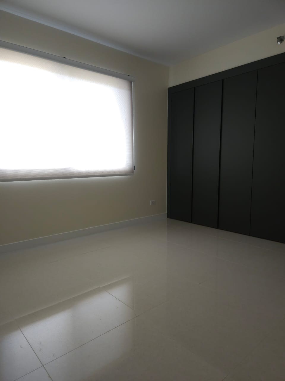 A room with a window and a wall-mounted cabinet.