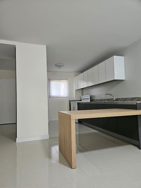 A kitchen with a wooden island in the middle of the room.