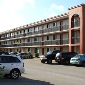A parking lot with cars and a building in the background.