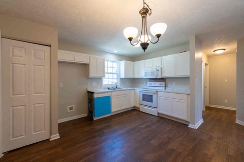 A kitchen with white cabinets and a blue island.