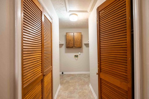A hallway with wooden doors and a tiled floor.