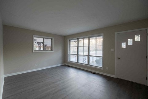 A large empty room with a door and a window.