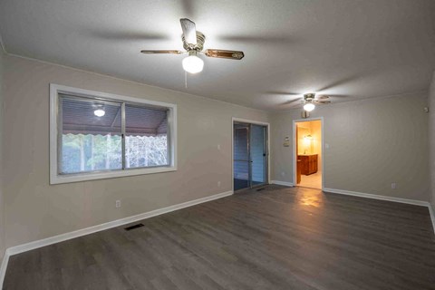 A room with a ceiling fan and a window with blinds.