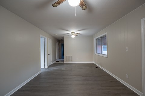 A spacious room with a ceiling fan and light fixture.