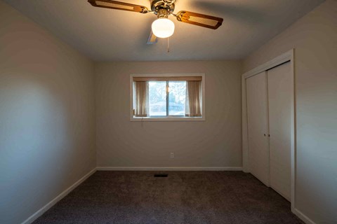 A room with a ceiling fan and a window.