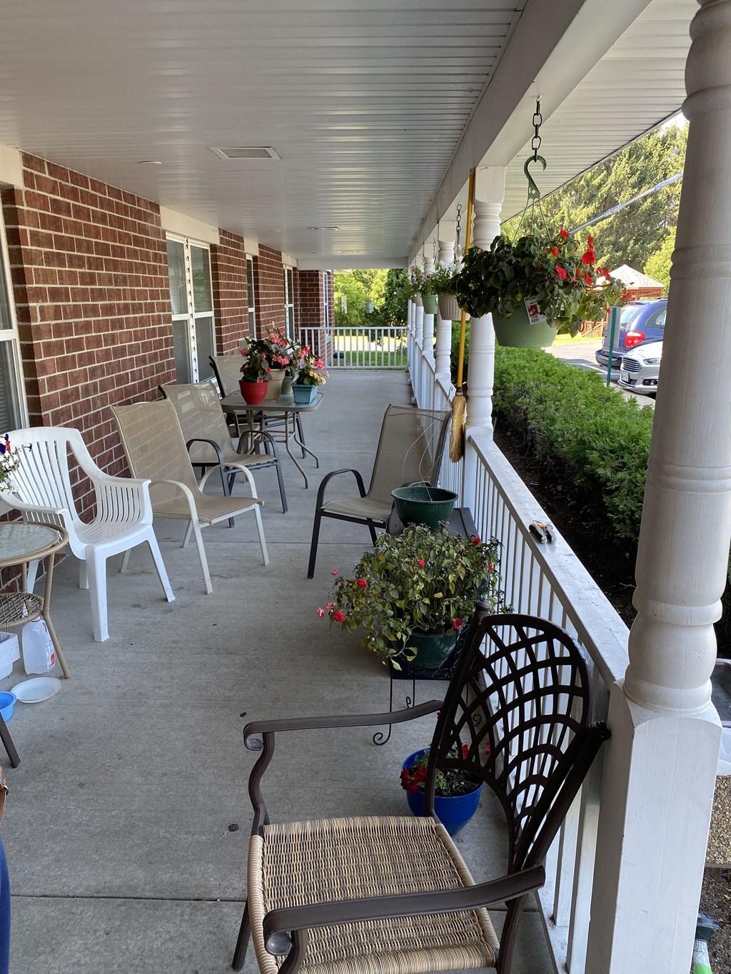 the front porch of a house with chairs and tables