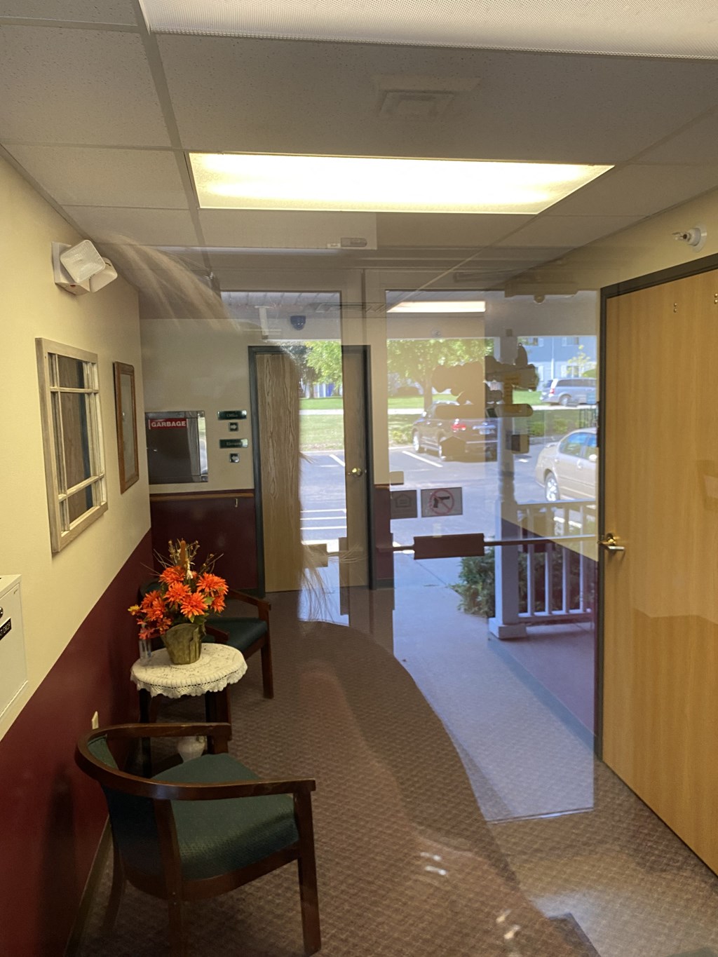 a lobby of a hospital with chairs and a table with flowers