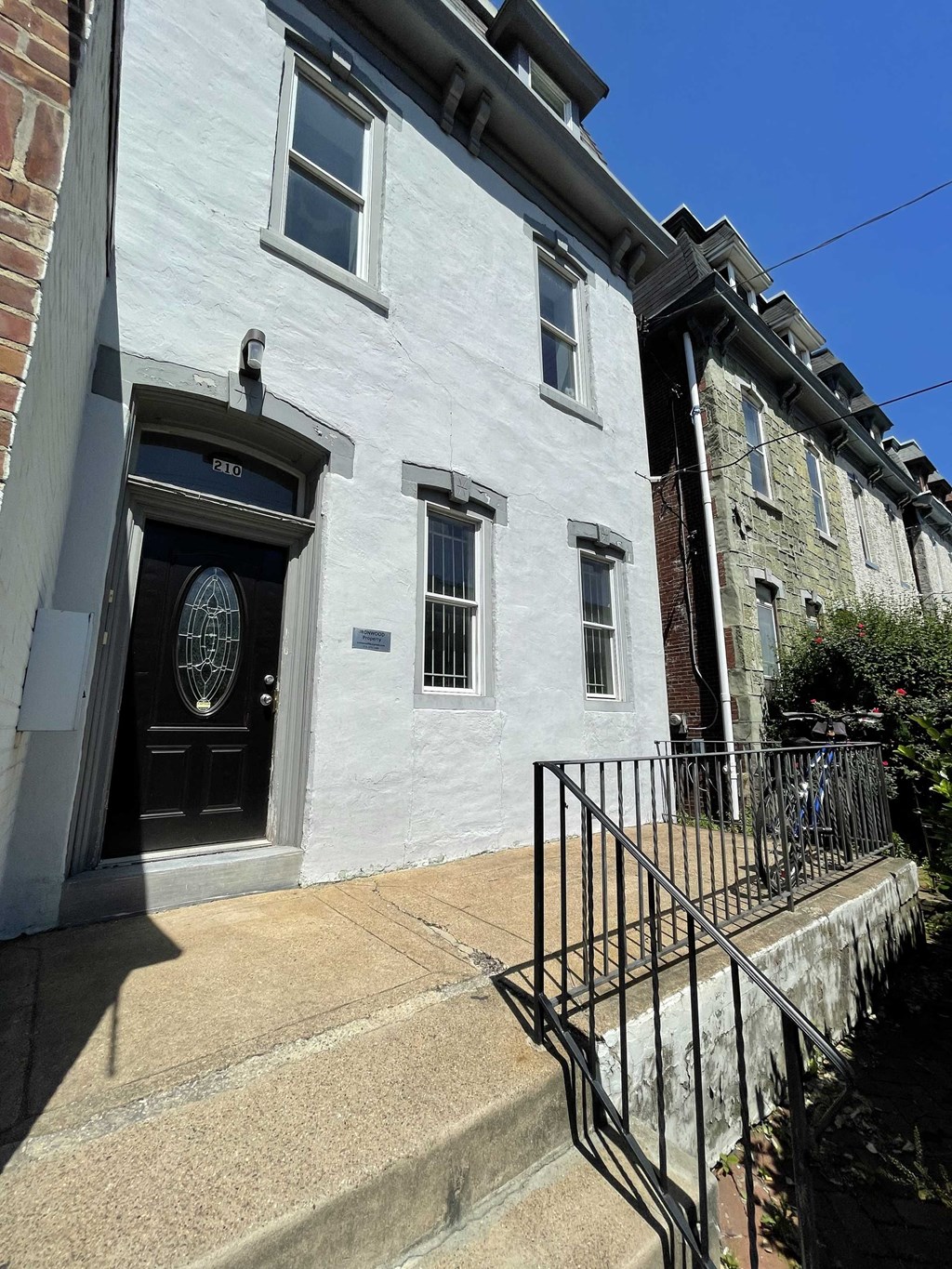 a white building with a black door and stairs