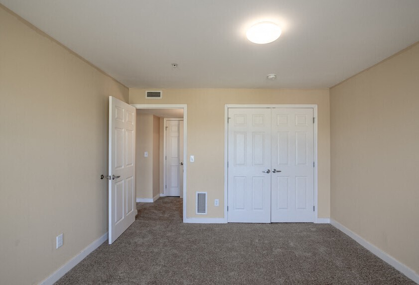 a empty room with two doors and a carpeted floor