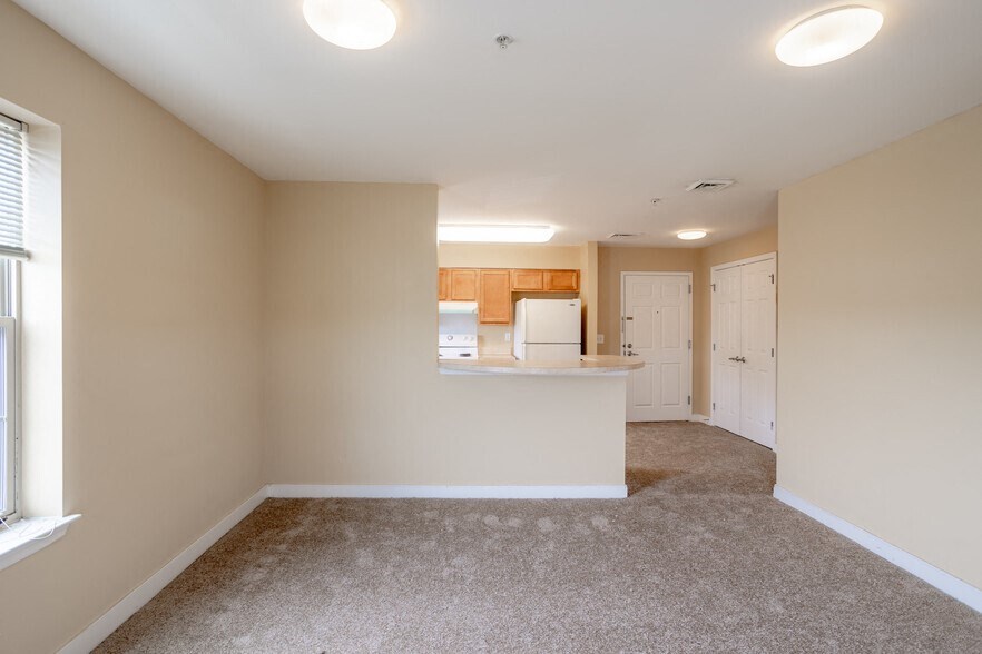 an empty room with a kitchen and a counter in it