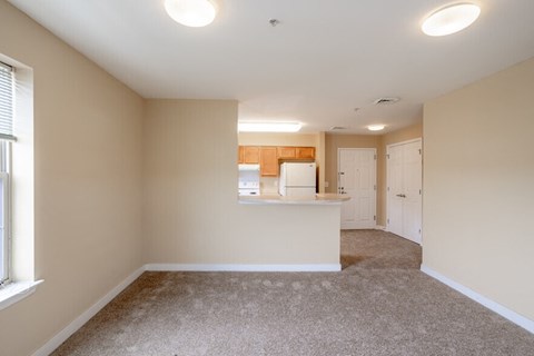 an empty room with a kitchen and a counter in it