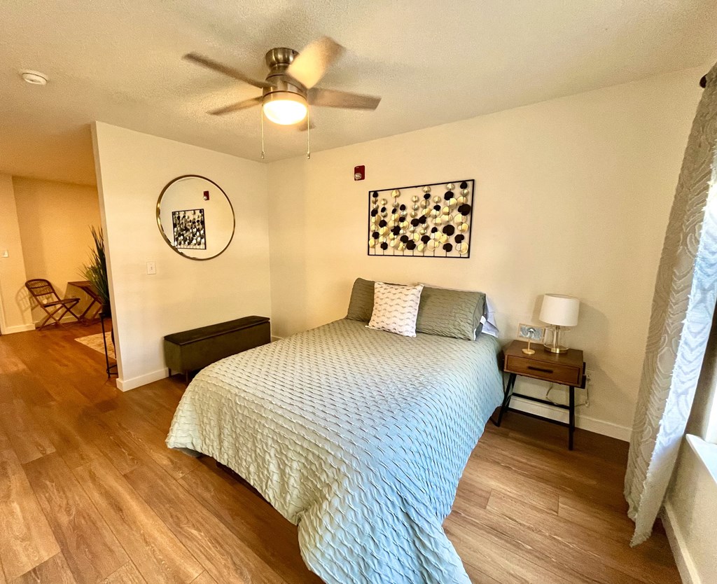 a bedroom with a large bed and a ceiling fan