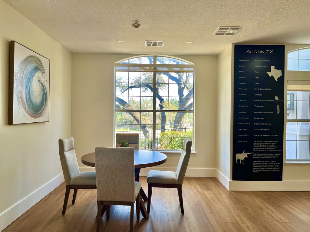 a dining room with a table and chairs and a large window
