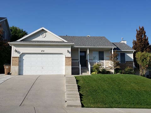 A house with a white garage door and a grey roof.