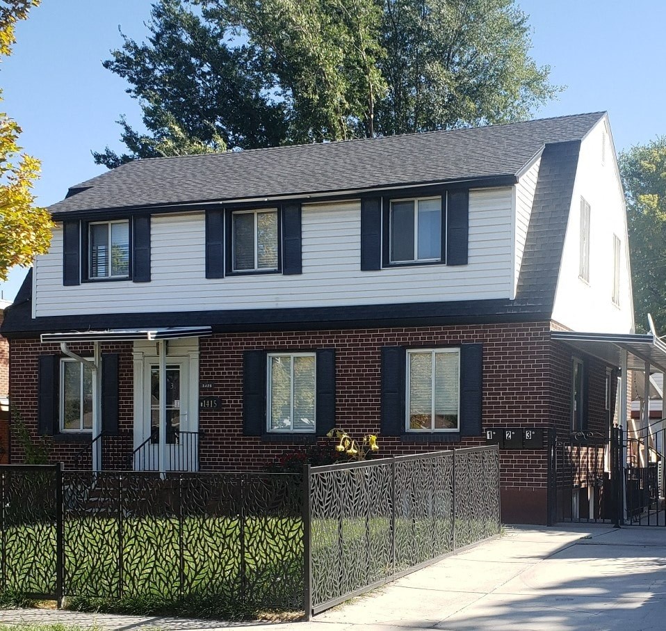 A house with a black fence and a white roof.