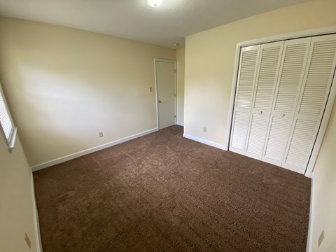 A room with brown carpet and white walls.