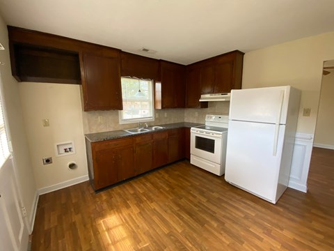 A kitchen with wooden cabinets and a white refrigerator.