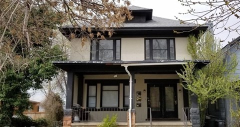 a house with a black and white roof and a porch