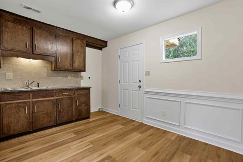 a kitchen with wooden cabinets and a white door