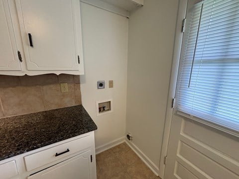 A kitchen with white cabinets and a granite countertop.