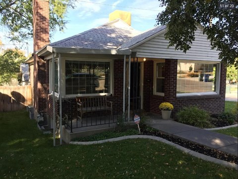 A small house with a porch and a flag on it.