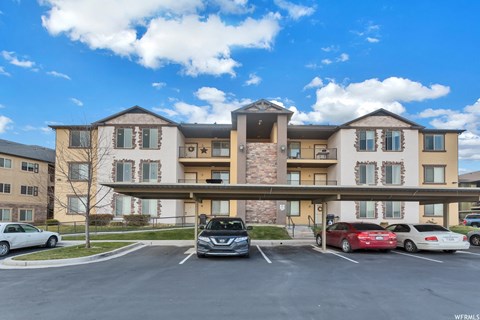 a large apartment building with cars parked in front of it