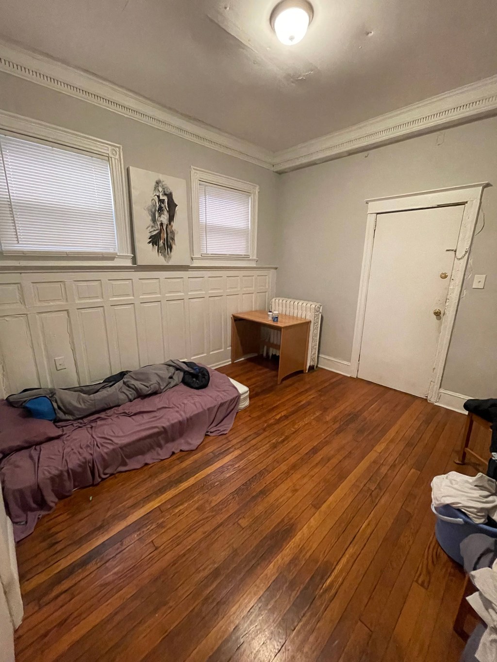 a bedroom with a bed and a wooden floor