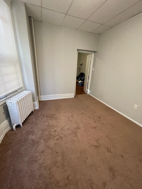 a living room with a carpeted floor and a radiator