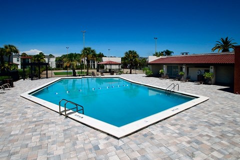 a large swimming pool with a house in the background