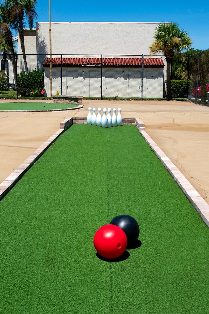 a bowling ball and bowling pins on a lawn