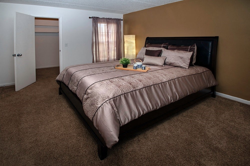 a bedroom with a bed and a door to a bathroom