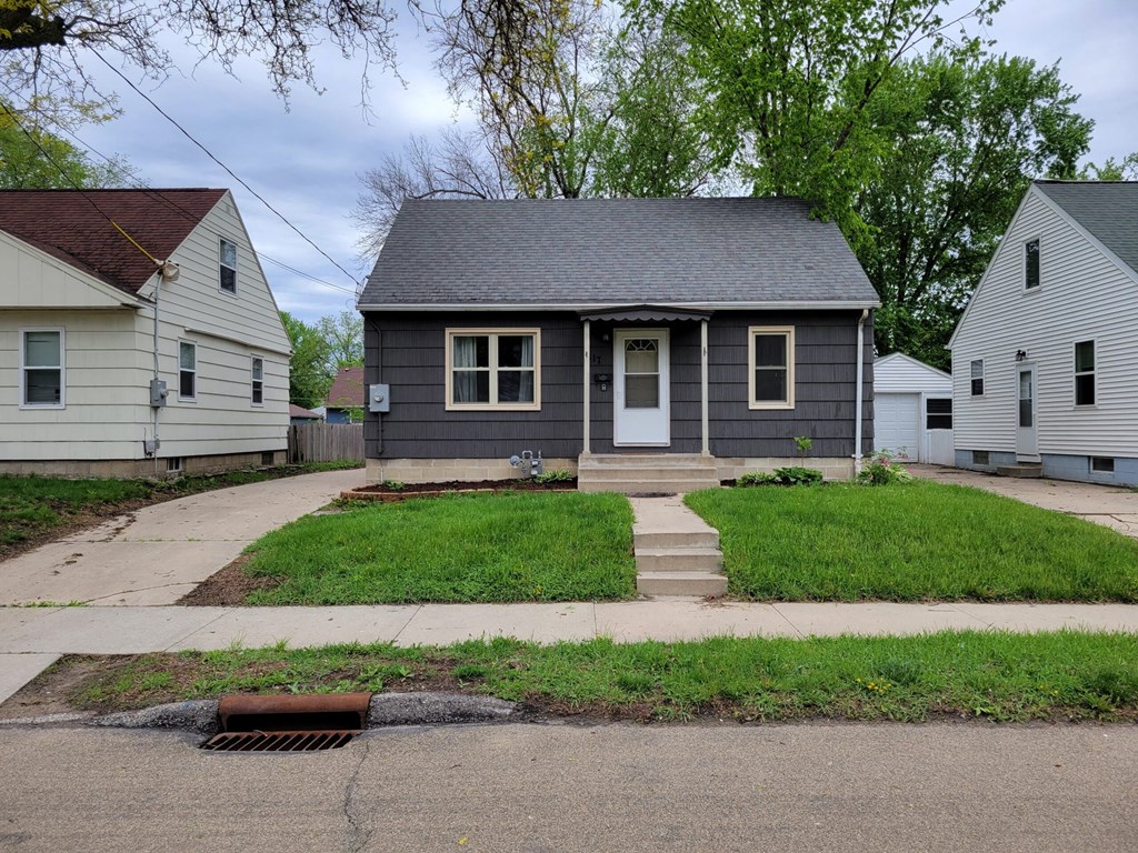 a gray house with a sidewalk in front of it