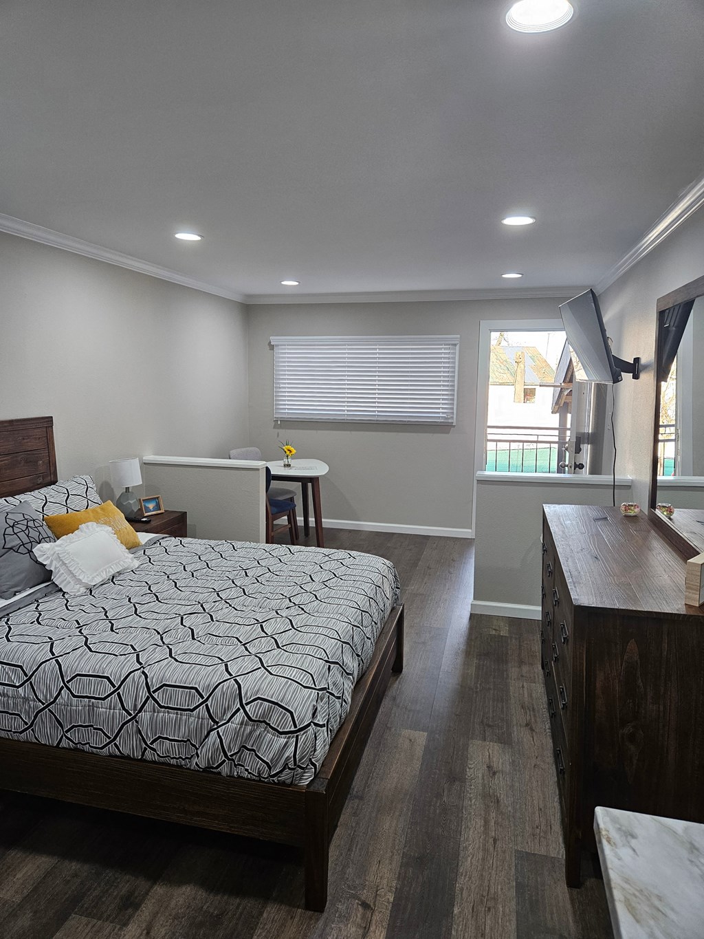 a bedroom with a bed and a desk and a window