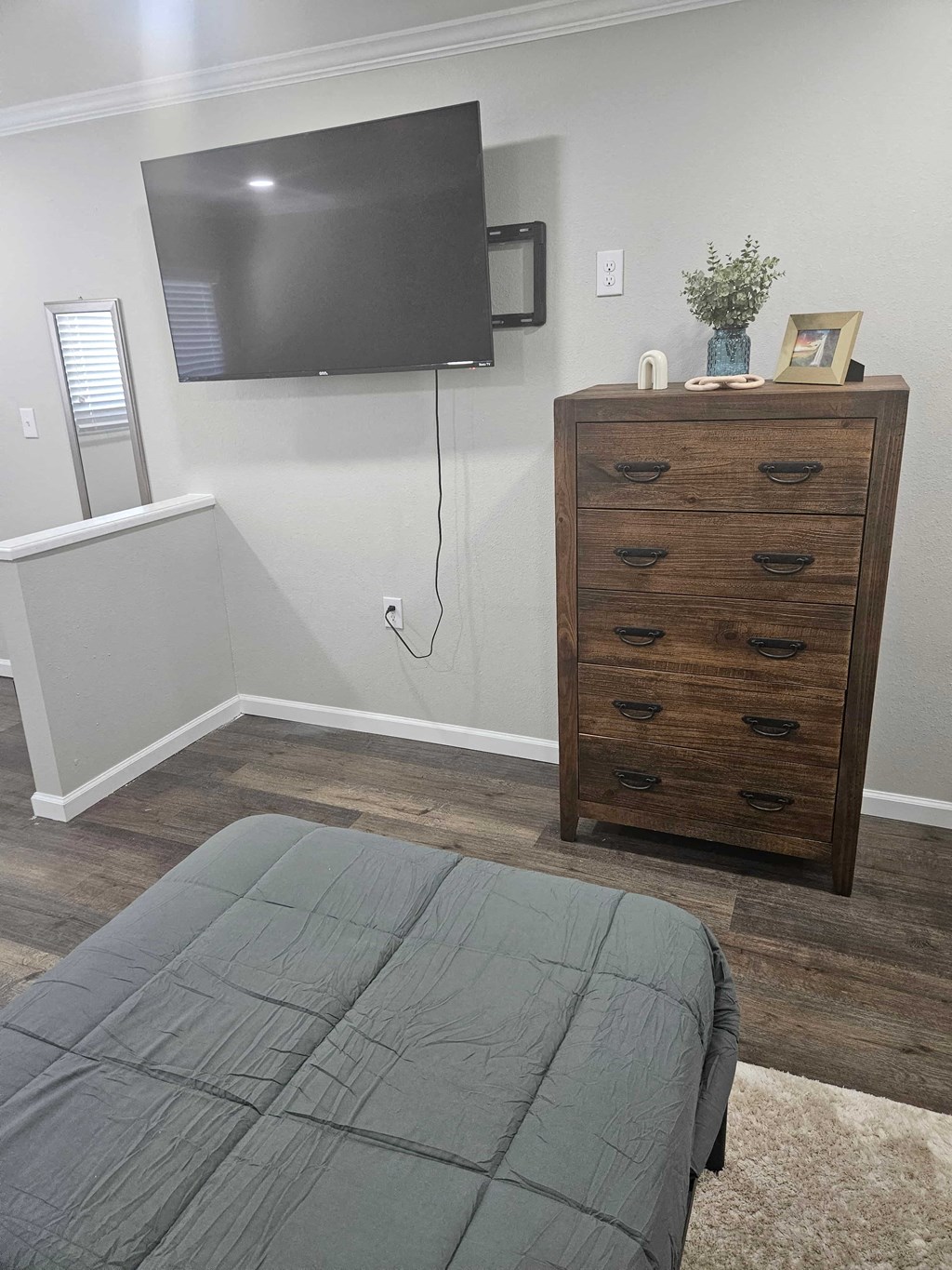 a bedroom with a tv and a bed and a dresser