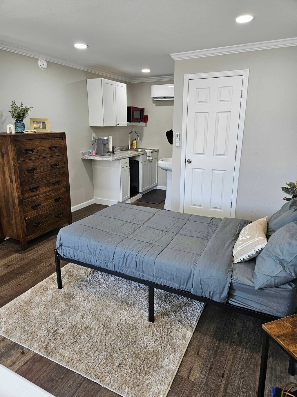 a bedroom with a bed and a kitchen