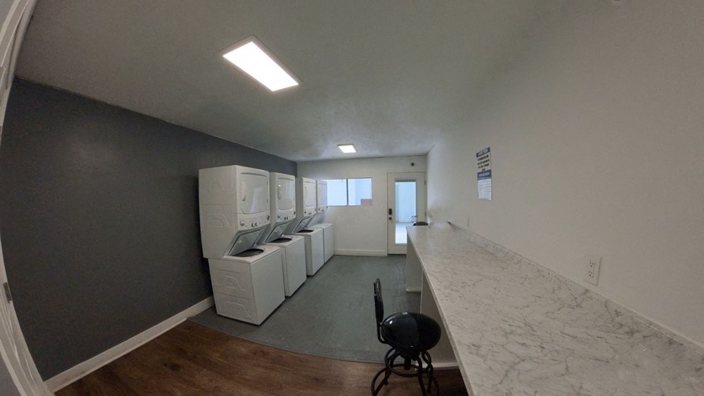 a laundry room with washers and dryers and a marble counter top