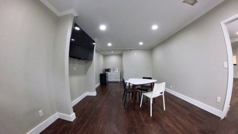 a dining room with a table and chairs and a tv