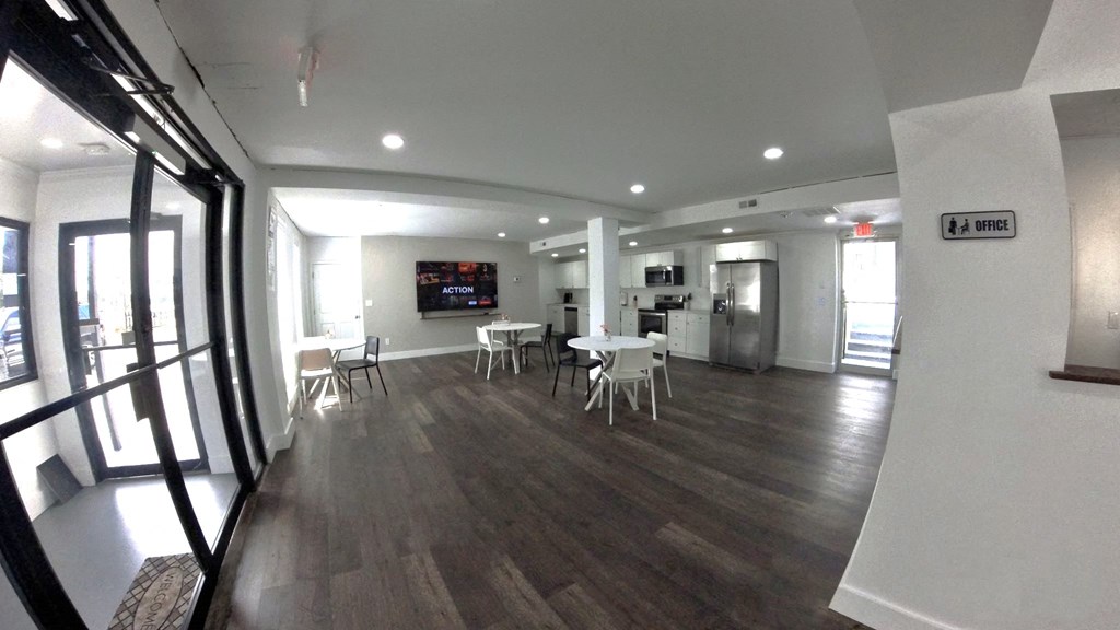 a large room with tables and chairs and a tv on the wall