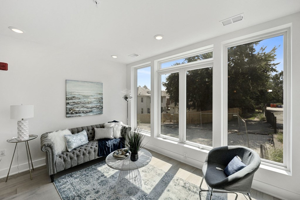 a living room with large windows and a couch and a table