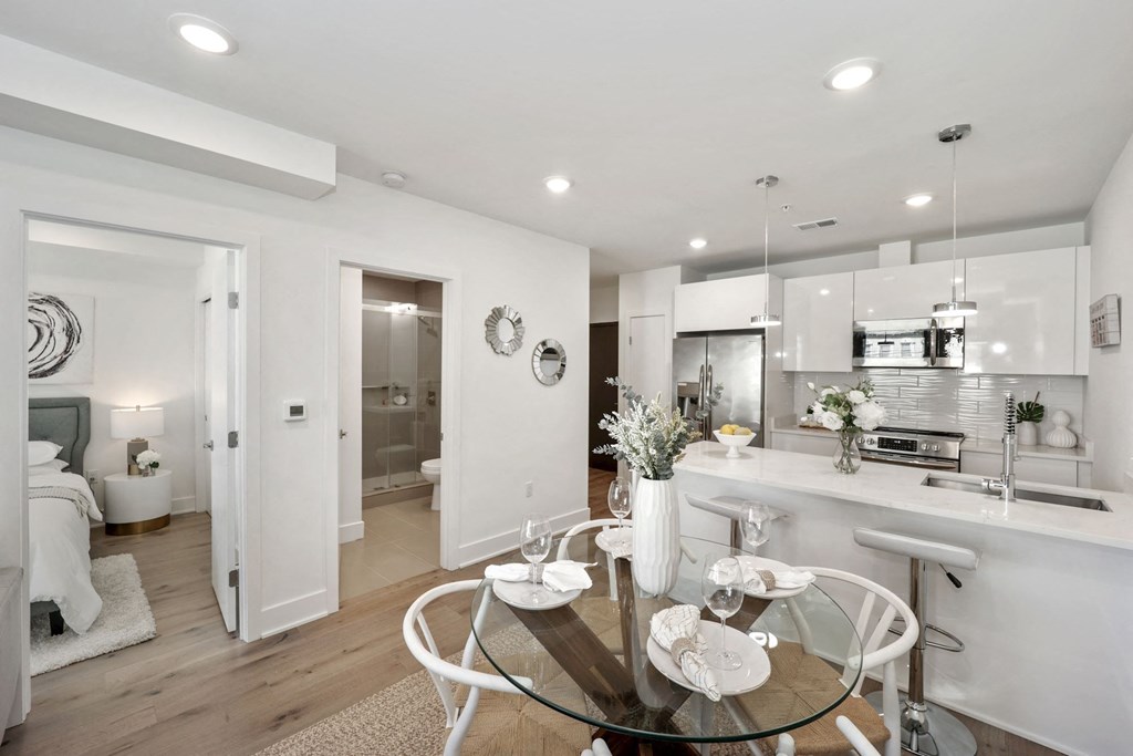 a living room and kitchen with a glass table
