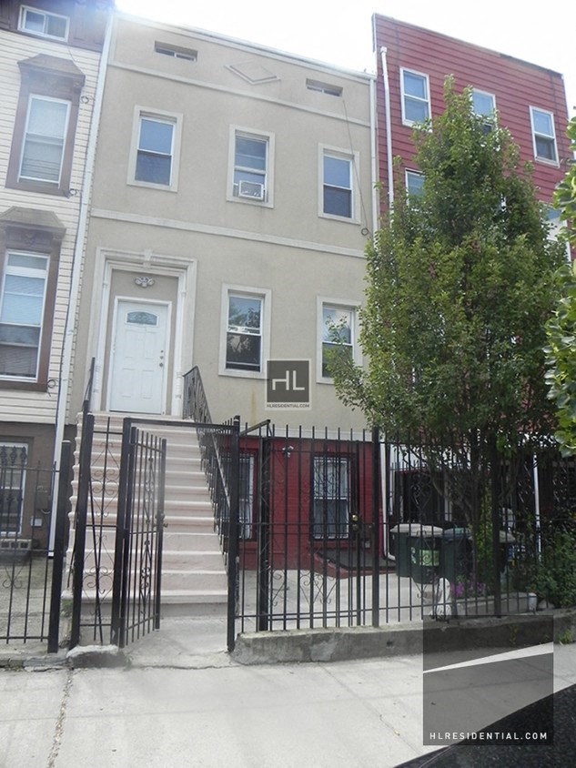 the front of a house with stairs and a gate