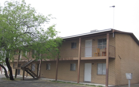 A brown building with a tree in front of it.