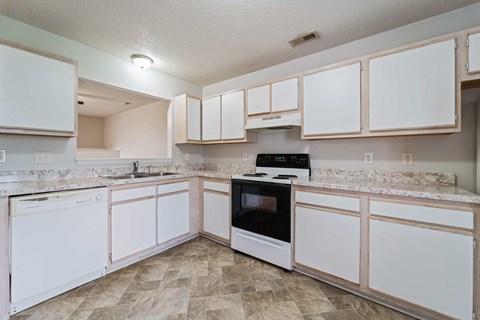 A kitchen with white cabinets and a black oven.