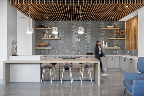 a kitchen with a table and chairs and a person walking