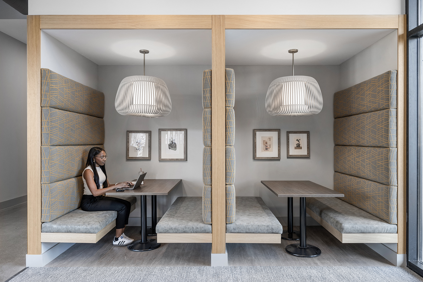 a woman sitting at a table in a room with a laptop