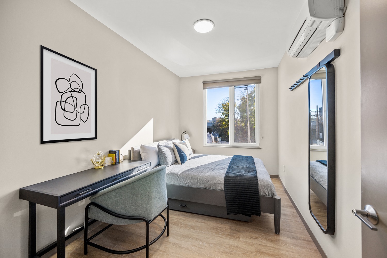 a bedroom with a bed and a desk and a window