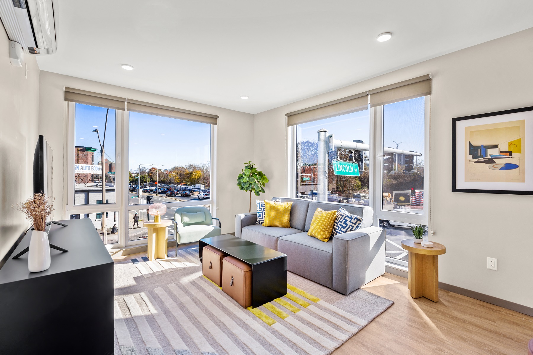 a living room with a couch and a rug and large windows