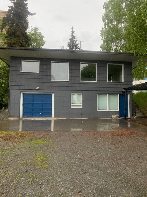 A grey house with a blue garage door.