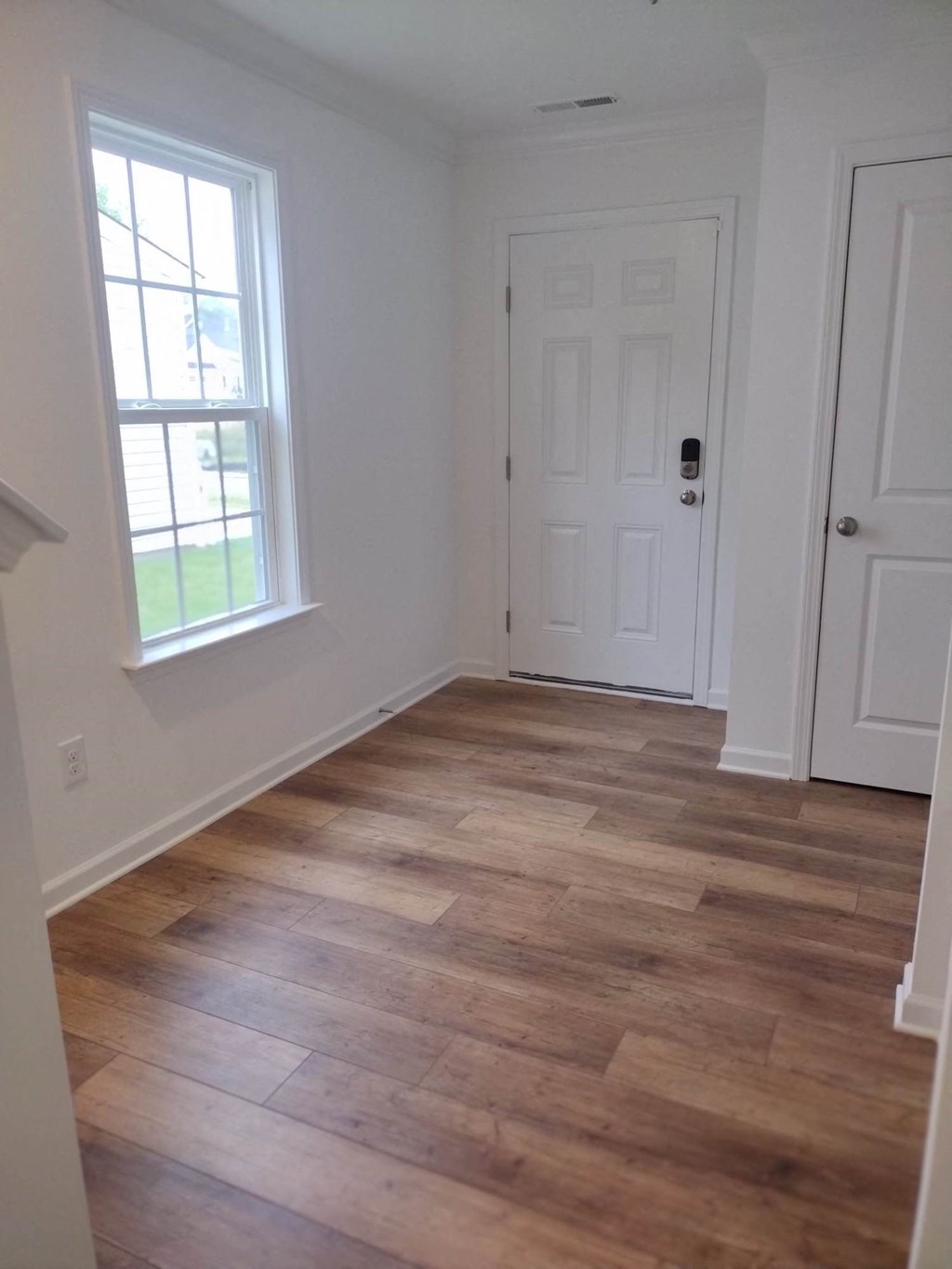 a living room with a hard wood floor and a window